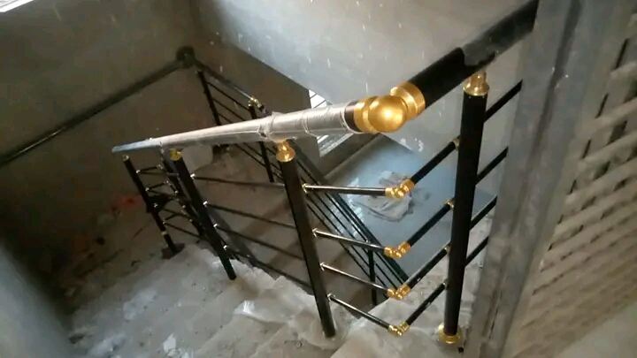 Stainless steel staircase railing in a sunlit indoor setting
